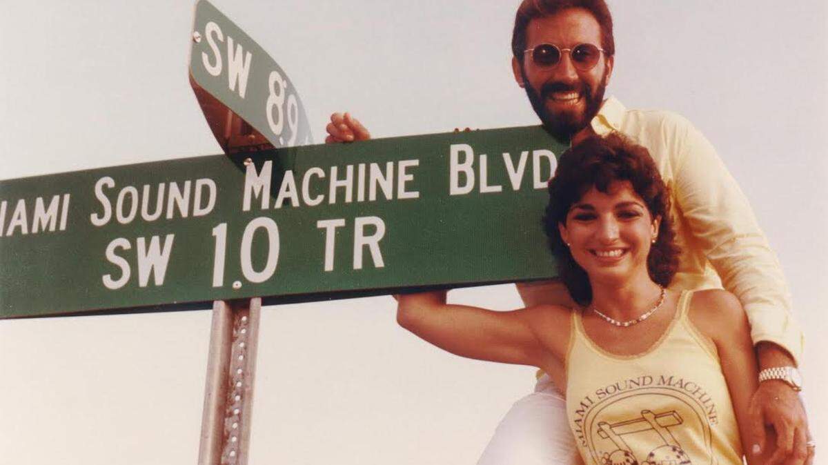 Gloria and Emilio Estefan, circa 1985, posing with Southwest 10th Terrace sign, after the street had been renamed Miami Sound Machine Boulevard.