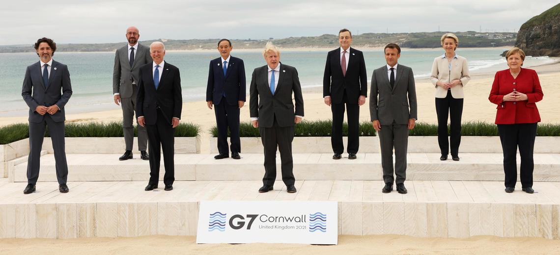 President Biden (wearing suit) participates in an important photo opportunity.