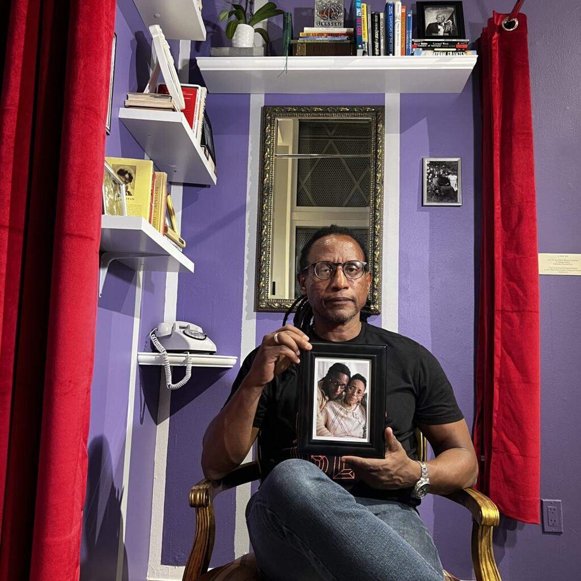 Show curator Carl-Philippe Juste sits in the installation “The Parlor.”