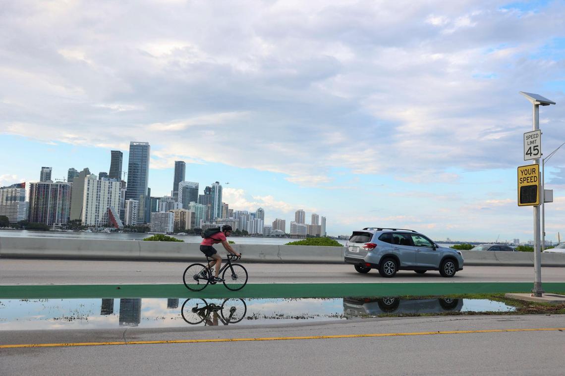 A biker rides near the spot that two cyclists were killed at the foot of the William Powell Bridge on the Rickenbacker Causeway leading to Virginia Key in Miami on May 16, 2022.