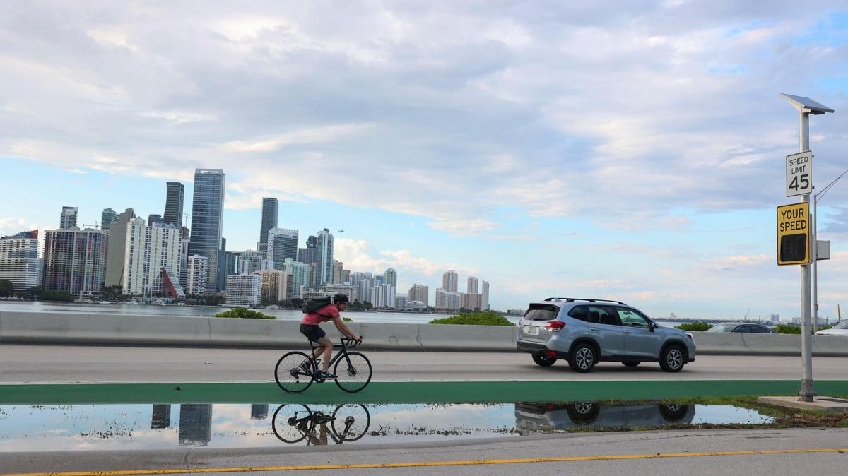 On Monday, May 16, 2022, a biker rides near the spot where two cyclists were killed Sunday at the foot of William Powell Bridge on the Rickenbacker Causeway leading to Virginia Key in Miami. Barriers separating bike lanes from traffic lanes will be coming to parts of the Rickenbacker, Miami-Dade Mayor Daniella Levine Cava said.
