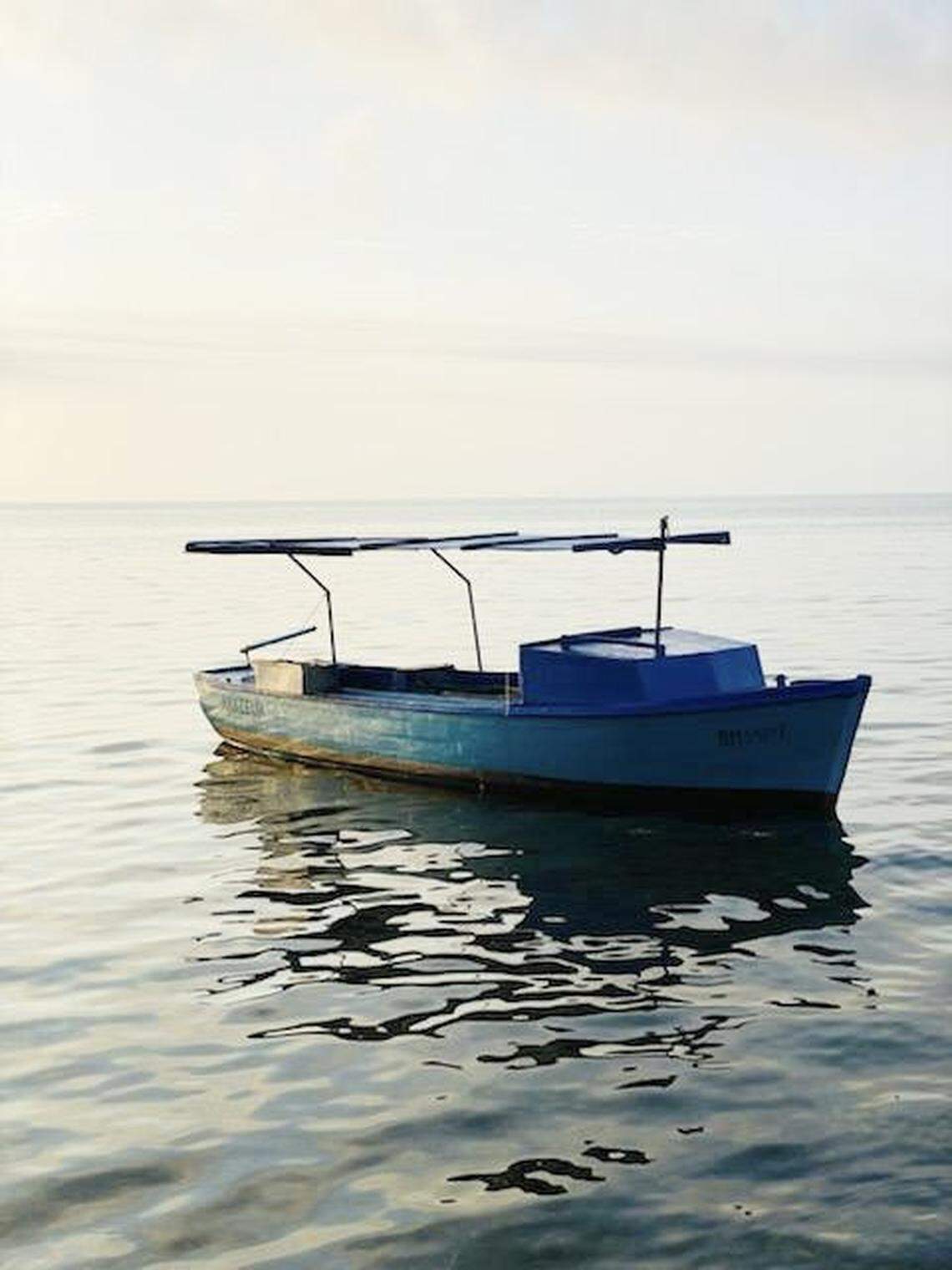 A small Cuban commercial fishing boat floats in shallow water off Summerland Key in the Florida Keys Thursday, March 17, 2022. The Border Patrol says 16 Cuban migrants arrived in the Keys on the vessel.