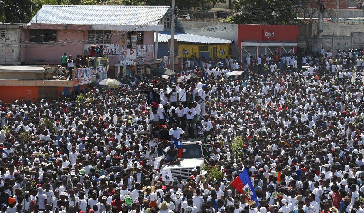 Protesters led by the art community demand the resignation of Haitian President Jovenel Moise as they march through Port-au-Prince, Haiti, Sunday, Oct. 13, 2019. Protests have paralyzed the country for nearly a month, shuttering businesses and schools.