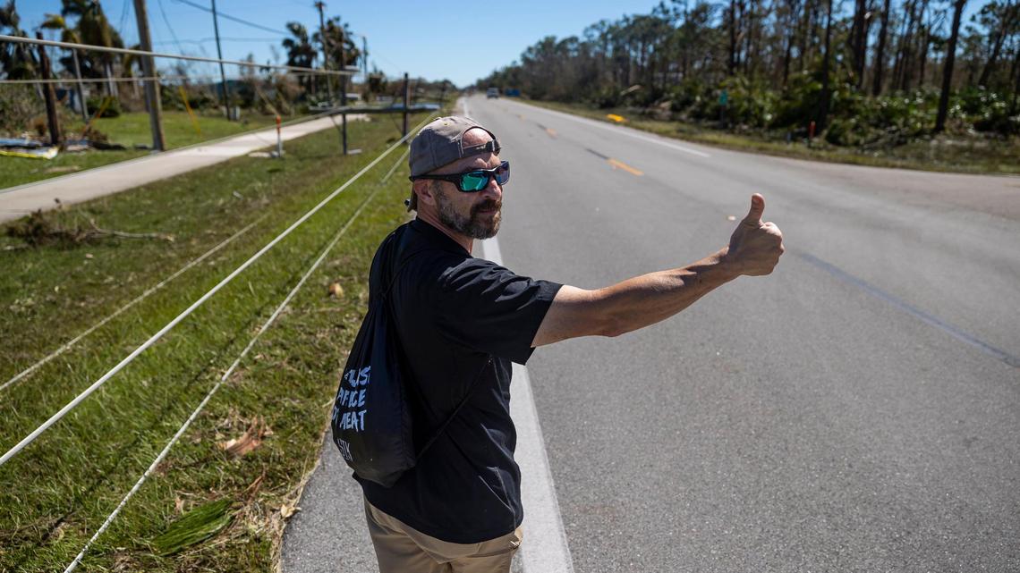 Mike Romeo, 53, hails a ride by sticking out his thumb in Pine Island on Friday, Sept. 30, 2022, in St. James City, Florida. Hurricane Ian made landfall on the coast of Southwest Florida as a Category 4 storm Wednesday afternoon, leaving areas affected with flooded streets, downed trees and scattered debris.