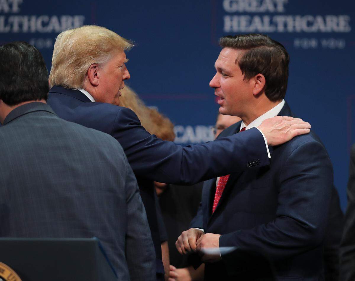 President Donald Trump speaks with Florida Gov. Ron DeSantis during an event at the Sharon L. Morse Performing Arts Center on October 3, 2019 in The Villages, Florida. President Trump spoke at the event about Medicare, and signed an executive order calling for further privatizing of it.