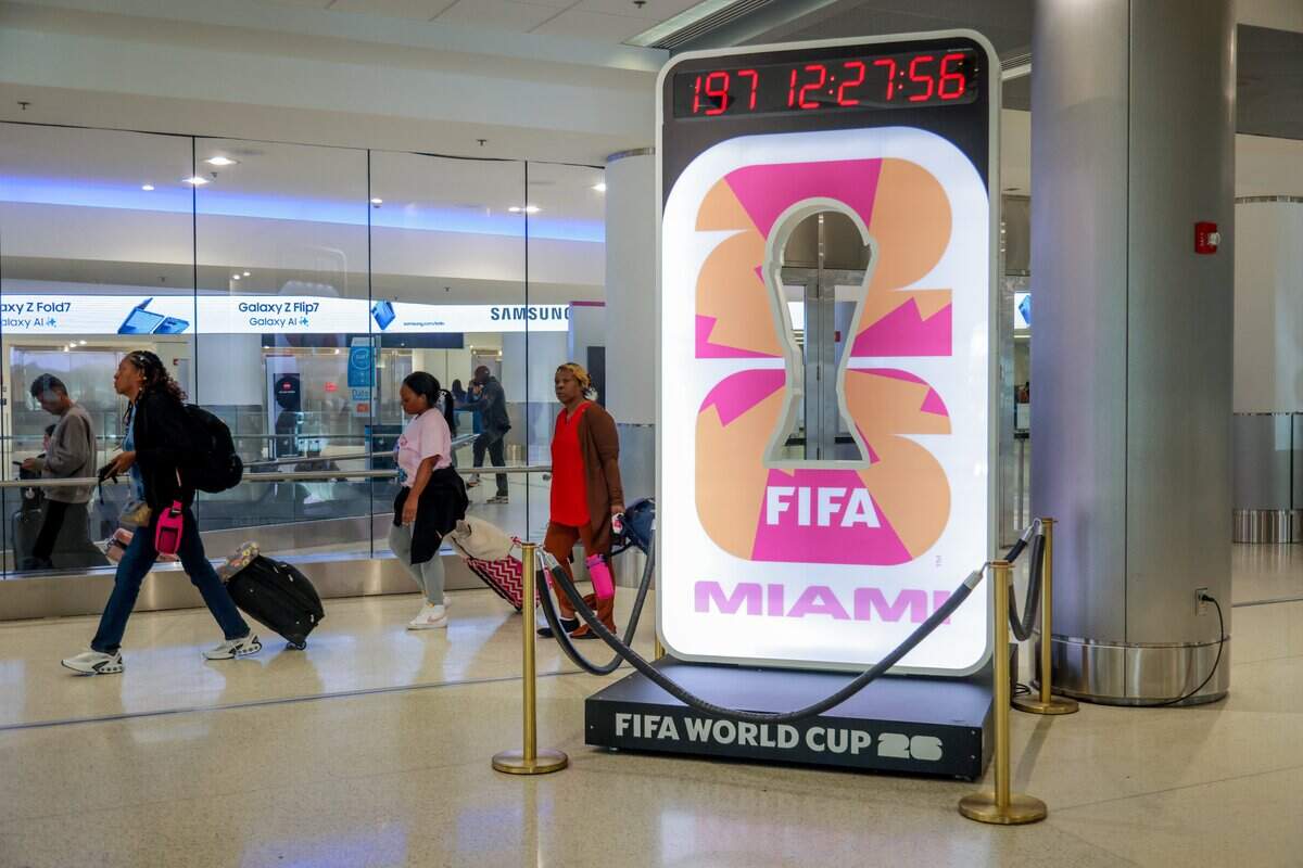 Travelers on Concourse D push their luggage by an installation with a countdown clock signaling the start of the 2026 FIFA World Cup at Miami International Airport on Tuesday, Nov. 25, in Miami, Fla.