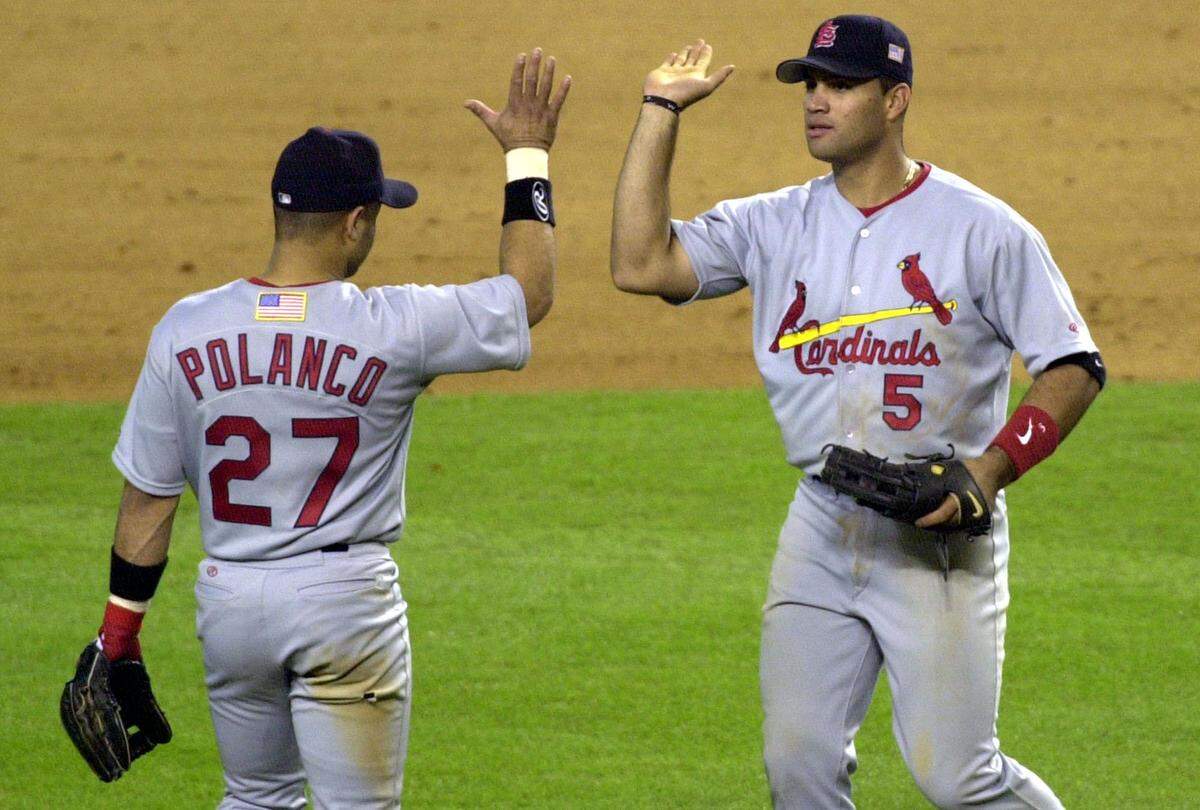 St. Louis Cardinals’ Placido Polanco (27) and Albert Pujols celebrate the Cardinals 4-1 victory over the Arizona Diamondbacks in the Game 2 of their National League Division Series Wednesday Oct. 10, 2001 in Phoenix. Pujols hit a two-run homer in the first inning off of Diamondbacks starter Randy Johnson. (AP Photo/Paul Connors)