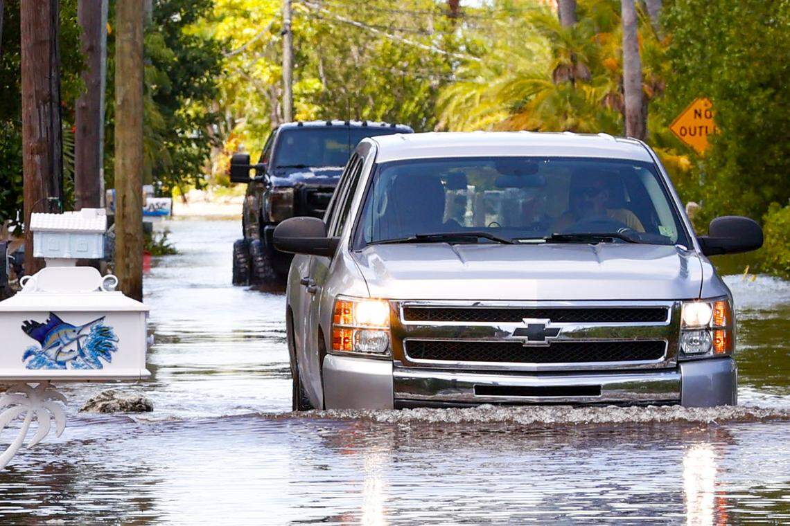 Trucks drive up North Blackwater Lane while flooded due to the effects of Hurricane Ian at Stillwright Point in Key Largo, Florida, on Thursday, September 29, 2022.