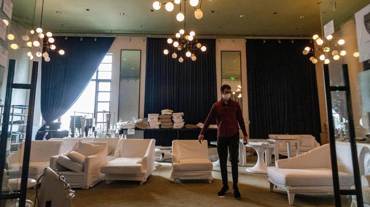 A man looks through a room full of items available at the liquidation sale going on at the Delano hotel. They are selling everything from the white couches to the sushi tables.