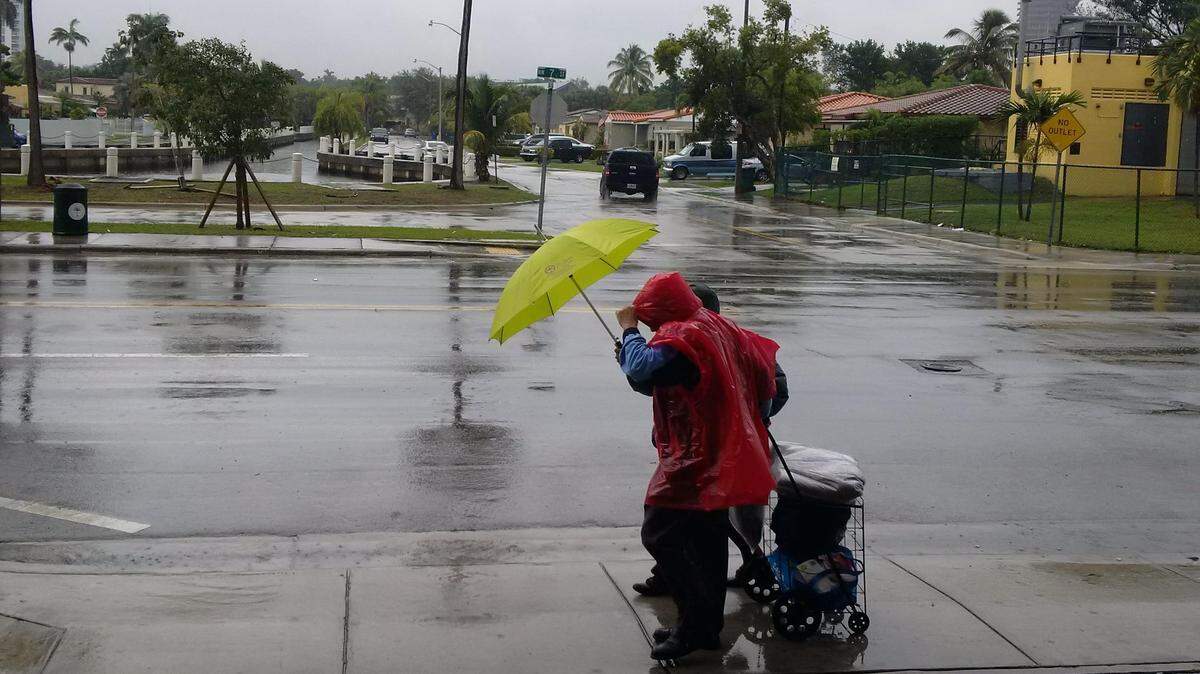 A couple wheels groceries down Northwest Seventh Street through Saturday’s rain.