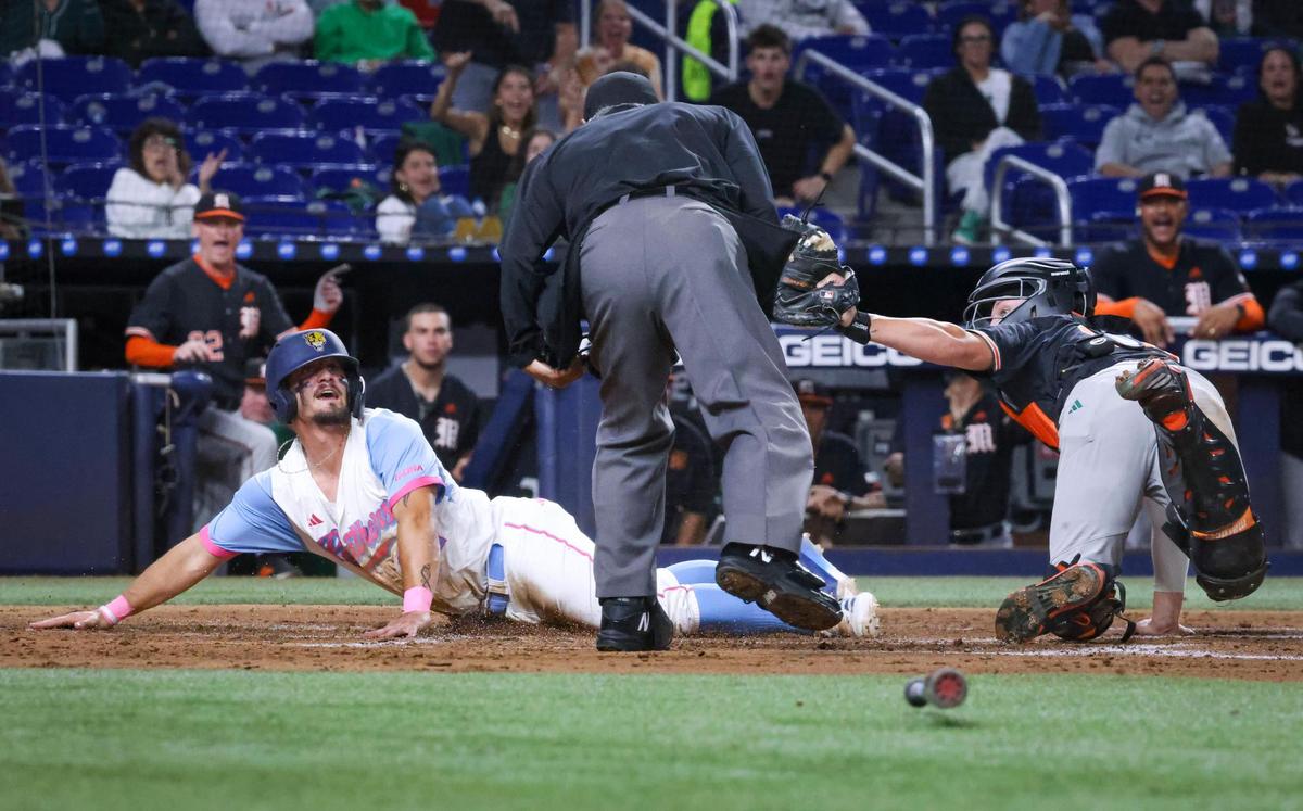 FIU catcher Brendan Roney (37) slides in safe to home plate and is tagged by Miami catcher Tanner Smith (30) during the third inning of a game on Tuesday, March 4, 2025, at loanDepot Park in Miami, Fla.