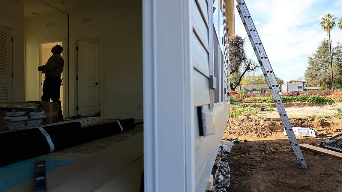 A worker helps assemble a newly manufactured 1200-square-foot ADU (accessory dwelling unit) on Thursday, Dec. 18, 2025 in Altadena, California. 