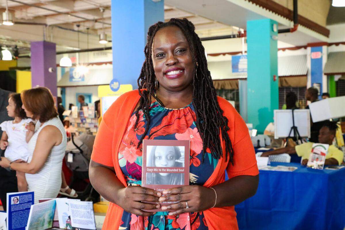 Sandra Jean Charite, an author at the Marketplace at the Little Haiti Book Festival. The festival features books available in several languages including English, Haitian Creole, and French.