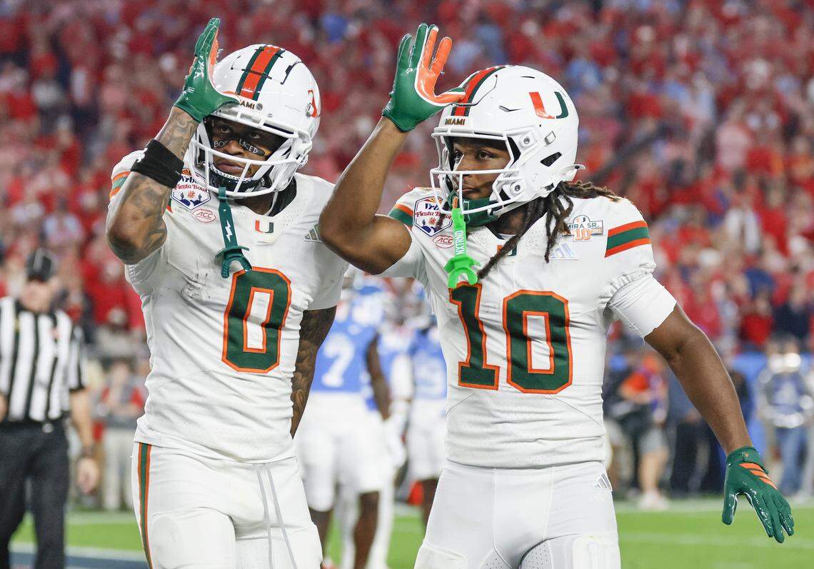 Miami Hurricanes wide receiver Keelan Marion (0) and wide receiver Malachi Toney (10) react after Marion scores in the first half of a College Football Playoff semifinal against the Mississippi Rebels in the Fiesta Bowl at State Farm Stadium on Thursday, January 8, 2026 in Glendale, Arizona.