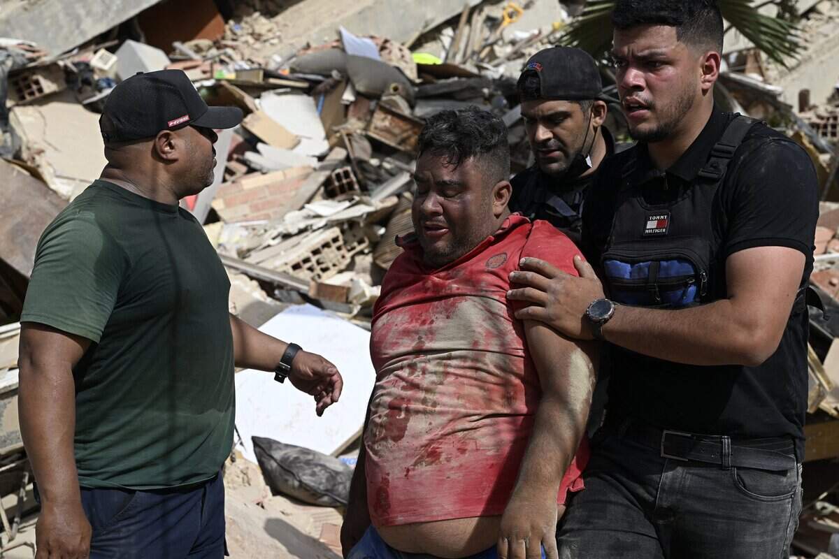 Volunteers help a man found amid rubble in Caraballeda, Venezuela, on June 25, 2026.