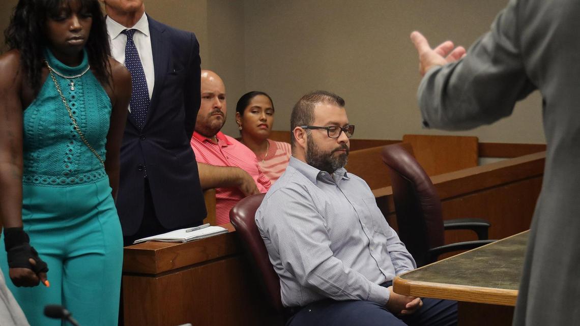 Alejandro Giraldo, right, the former Miami-Dade cop who was convicted of unlawfully tackling Dyma Loving, left, to the ground and then writing a false arrest report, sits quietly as Loving is gestured by the prosecutor to give a statement in court during Giraldo’s sentencing on Wednesday, June 22, 2022, at the Richard E. Gerstein Justice Building in Miami.