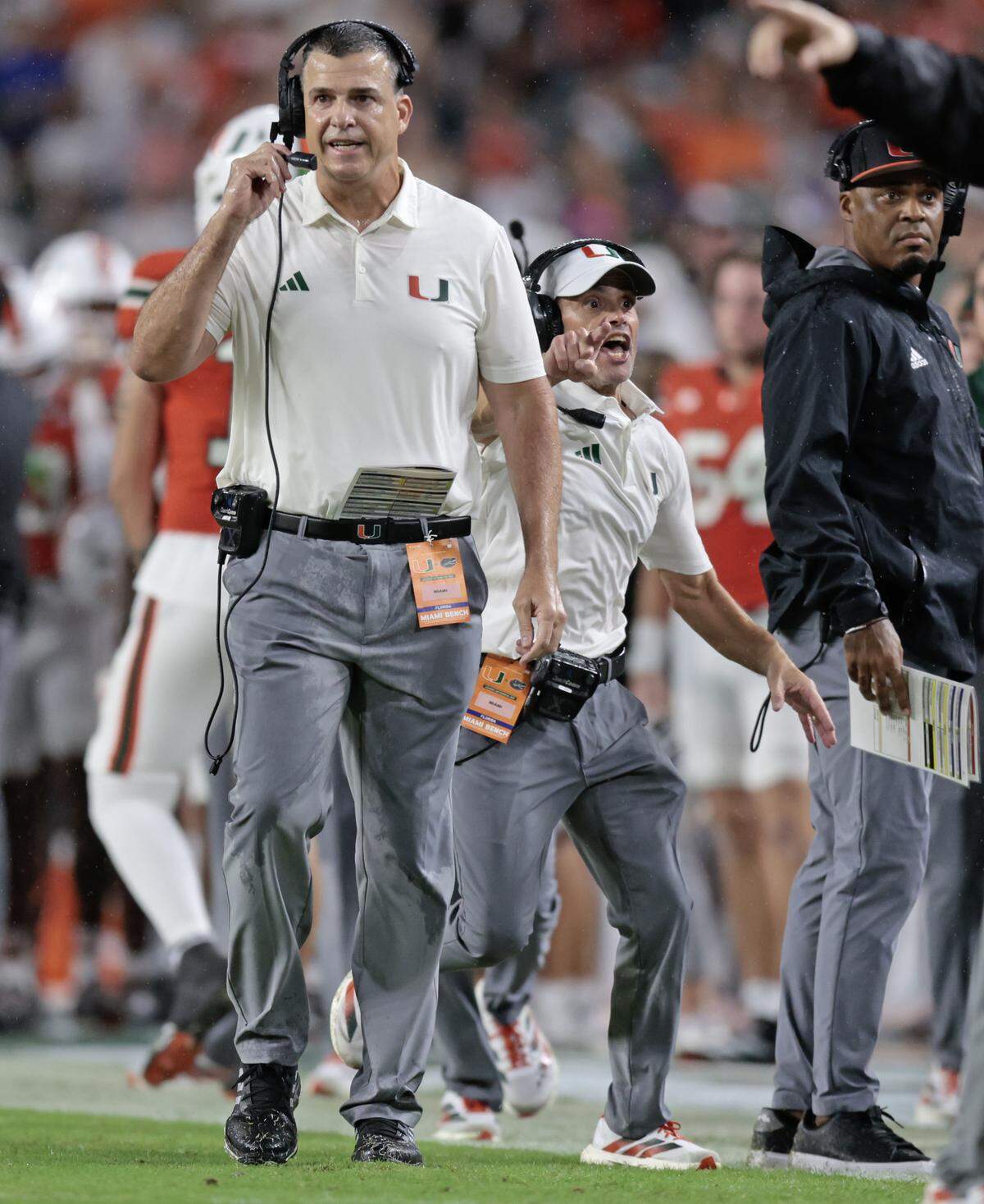 Miami Hurricanes head coach Mario Cristobal, at left, and assistant head coach and offensive line coach Alex Mirabal react during their NCAA football game against the Florida Gators at Hard Rock Stadium in Miami Gardens, Florida, on Saturday, September 20, 2025.