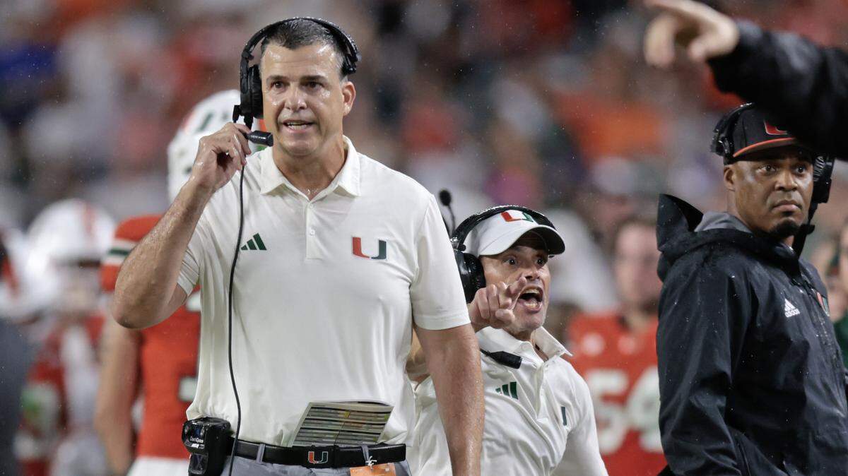 Miami Hurricanes head coach Mario Cristobal, at left, and assistant head coach and offensive line coach Alex Mirabal react during their NCAA football game against the Florida Gators at Hard Rock Stadium in Miami Gardens, Florida, on Saturday, September 20, 2025.