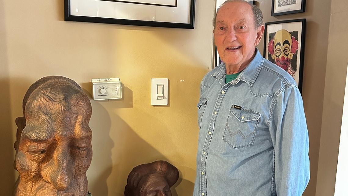Longtime ENT doctor and artist Robert E. Pickard stands with some of his wooden sculptures, lithographs and paintings. He writes about his life’s journey and service helping others in a new autobiography.