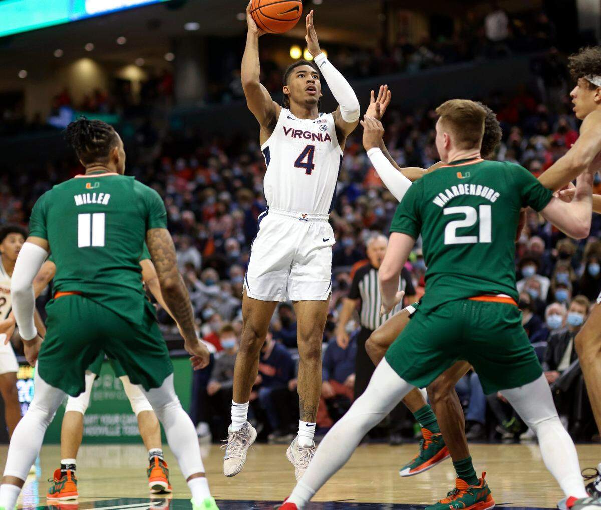 Virginia guard Armaan Franklin (4) shoots between Miami guard Jordan Miller (11) and Miami forward Sam Waardenburg (21) during an NCAA college basketball game in Charlottesville, Va., Saturday, Feb. 5, 2022. (AP Photo/Andrew Shurtleff)