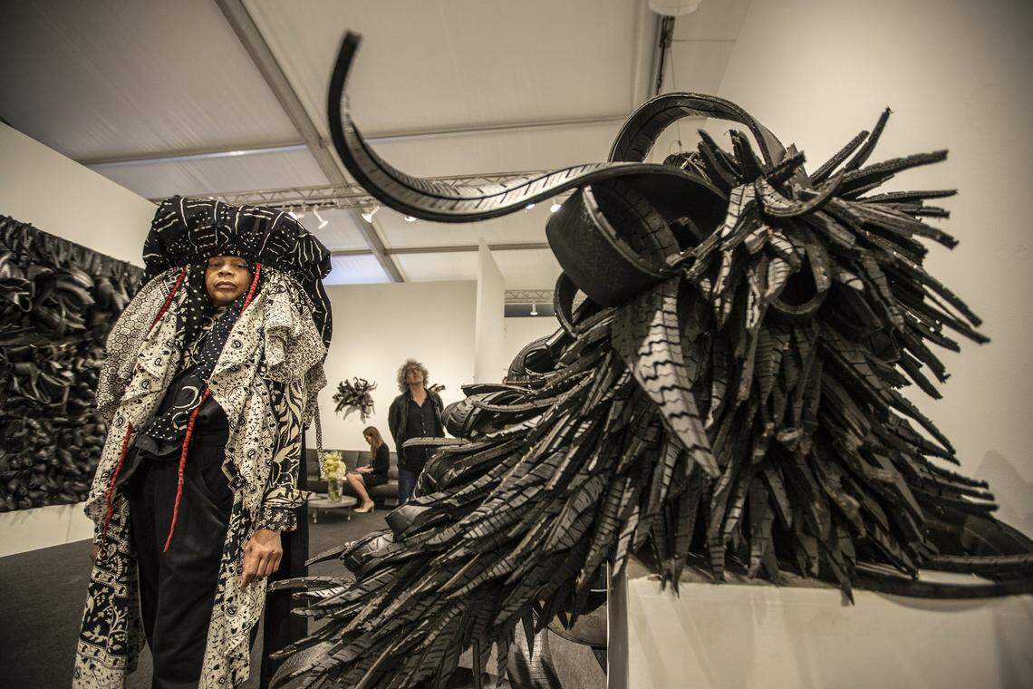 Artist Chakaia Booker and her work, “Egress,” made of rubber tires and stainless steel, at Art Miami 2019. 