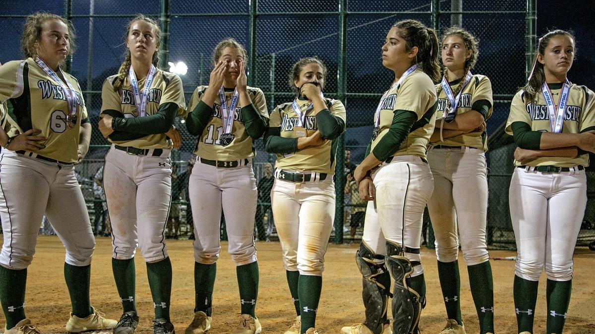 Westminster Christian softball players watch Trinity Christian girls celebrate their winning in softball Class 4A State Championship at Jackie Robinson Training Complex in Vero Beach on Wednesday, May 22, 2019.