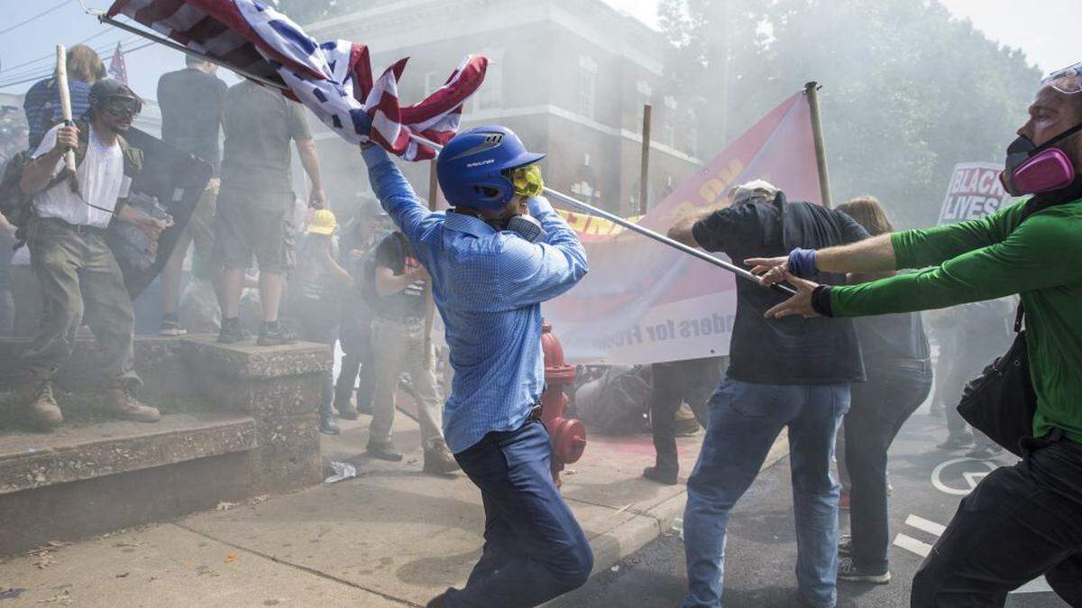In 2017, a white supremacist tries to strike a counter protester with a white nationalist flag during clashes at Emancipation Park in Charlottesville, Virginia.
