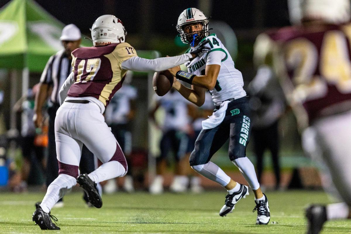Saint Brendan quarterback Julian Fresen (14) sets up to throw the ball while under pressure by Miami Springs middle linebacker Adrian Gilbert (17) during a high school football game in Miami, Florida, on Friday, September 29, 2023.