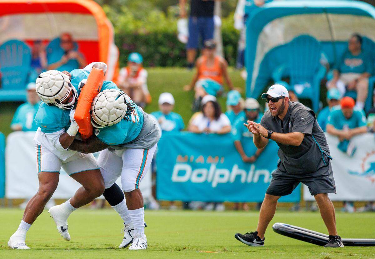 Miami Dolphins defensive line coach Austin Clark works with Dolphins defensive tackles Christian Wilkins (94) and John Jenkins (77) during NFL football training camp at Baptist Health Training Complex in Hard Rock Stadium on Sunday, August 7, 2022 in Miami Gardens, Florida.