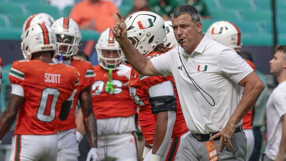 Miami Hurricanes head coach Mario Cristobal signals towards players before the start of the NCAA football game against the South Florida Bulls at Hard Rock Stadium in Miami Gardens, Florida, on Saturday, September 13, 2025.