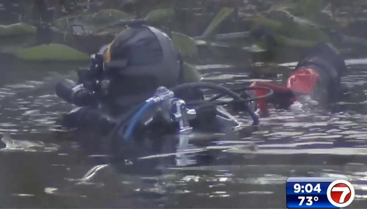 Divers search a canal in Pompano Beach where a car with a woman and child inside plunged into the water on Wednesday, Feb. 16, 2022.