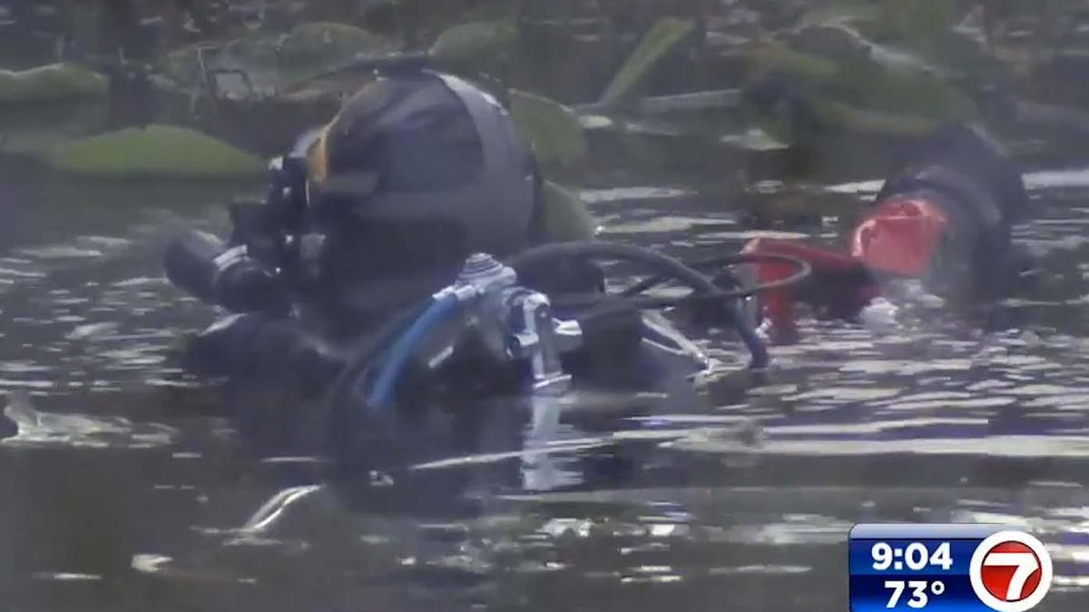 Divers search a canal in Pompano Beach where a car with a woman and child inside plunged into the water on Wednesday, Feb. 16, 2022. (Photo courtesy of WSVN - Channel 7)