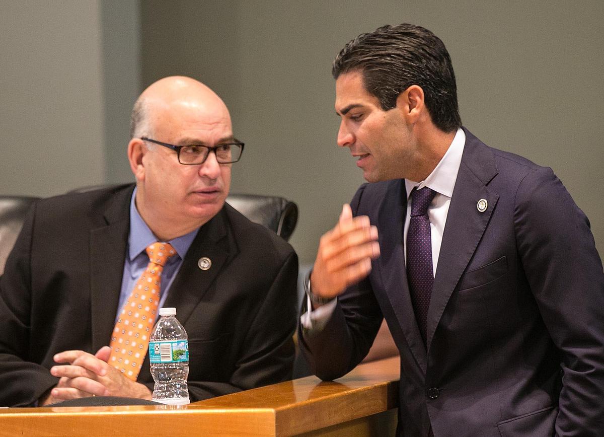 Miami Mayor Francis Suarez, right, chats with City Manager Emilio Gonzalez during the City Commission meeting on Tuesday, Aug. 14, 2018.