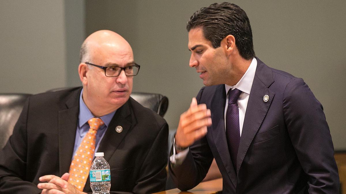 Miami Mayor Francis Suarez, right, chats with City Manager Emilio Gonzalez during a 2018 city commission meeting.