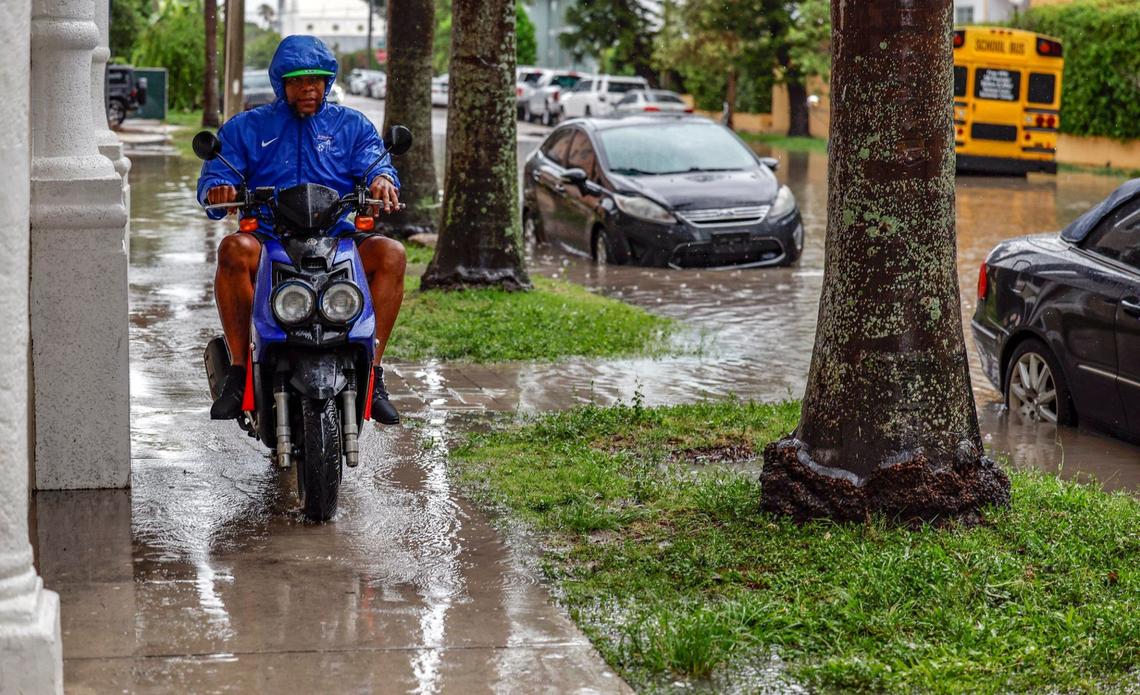 Oscar Gonzalez rides his motorcycle to avoid the flooded street along N.E. 23 Street in Miami, Florida on Wednesday, June 12, 2024.