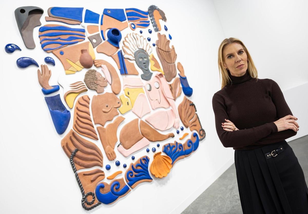 Artist Nina Surel is photographed next to one of her works displayed by Spinello during Art Basel at the Miami Beach Convention Center on Wednesday, Dec. 4, 2024, in Miami Beach, Fla.