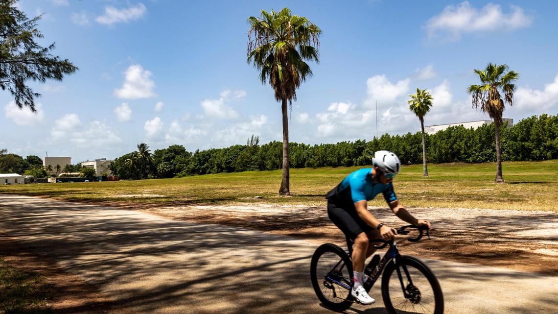 Miami, Florida, July 28, 2022 - A cyclist makes his way past a plot of land between the Virginia Key Outdoor Center and the mountain bike course at North Point, adjacent to the sewage treatment plant in Virginia Key. Miami has considered the possibility of taking people experiencing homelessness off the streets and moving them to a city-sponsored encampment on this site in Virginia Key.