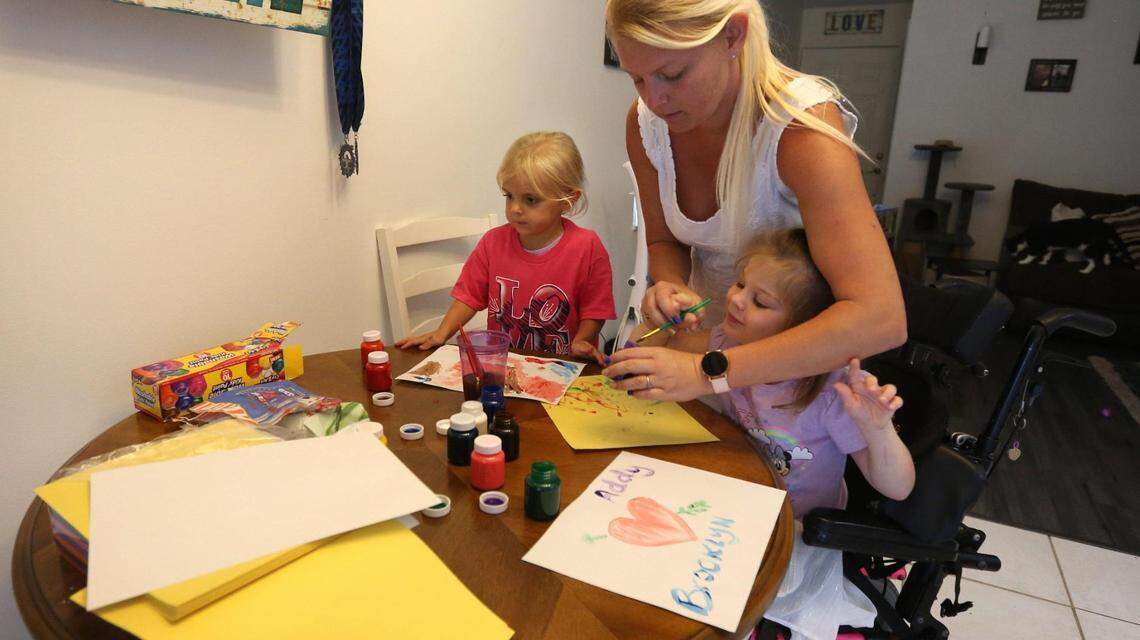 Ashley Grant helps Brooklyn with her painting. Alongside them in the pink shirt is Brooklyn’s sister Addy Stromquist.