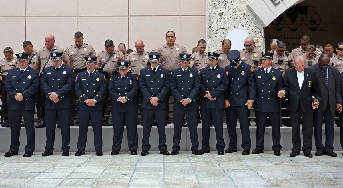 First responders bow their heads as FIU holds a moment of silence to commemorate the one-year anniversary of the bridge collapse during ceremony at Betty B. Chapman Student Plaza on Friday, March 15, 2019.