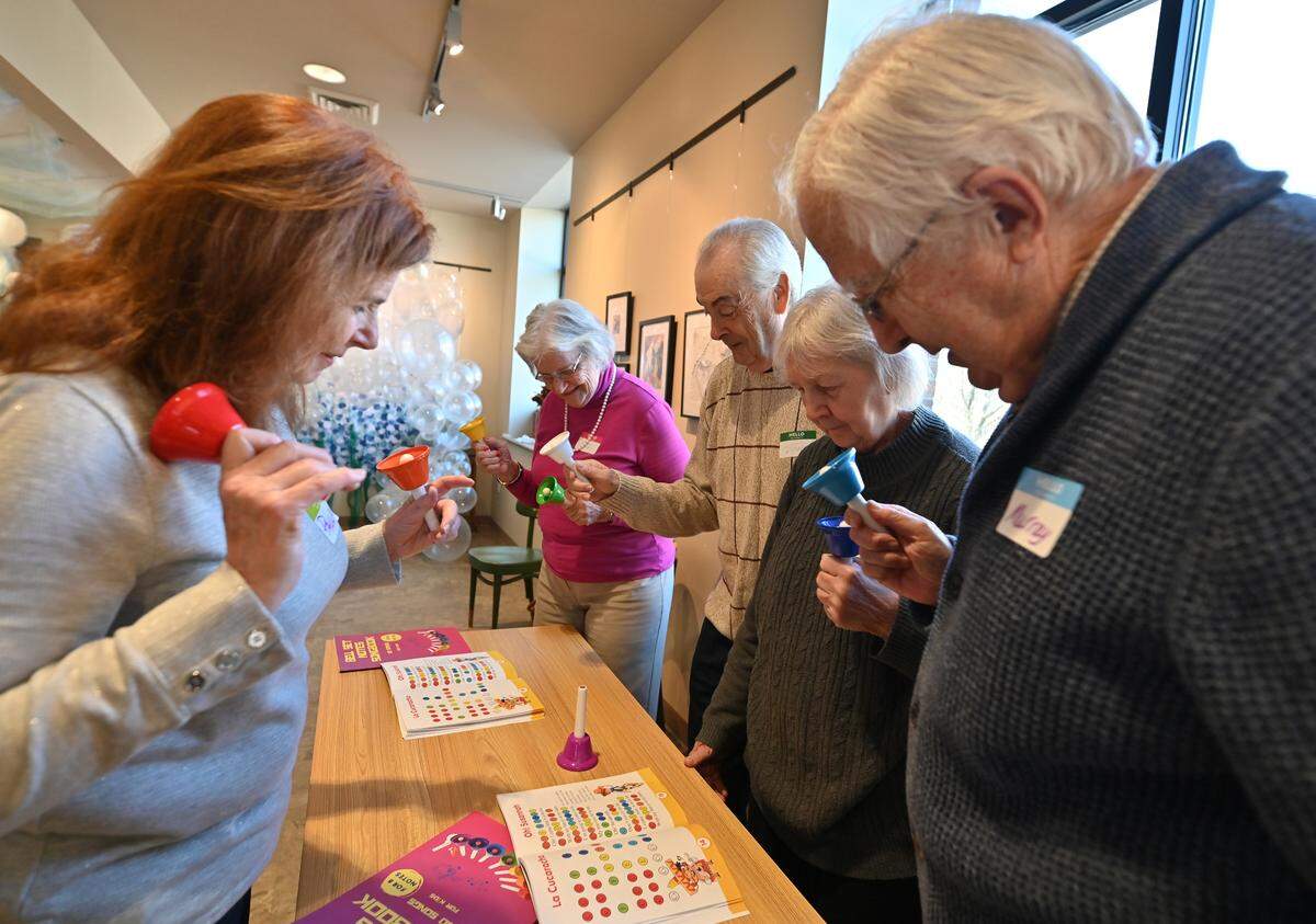 Paula Baillie, from left, leads Sharon Hannamaker, Joe Edwards, Barb Edwards, and Murray Small as they play the bells at The Gathering Place, a memory cafe in Clarks Summit, Pennsylvania.