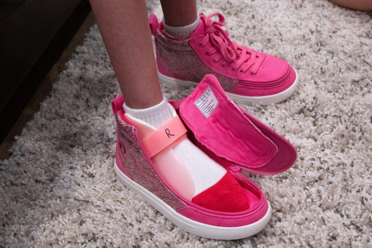 Riley Lowe, 15, has stylish pink BILLY Footwear adaptive shoes that allow her foot to be placed directly inside. 