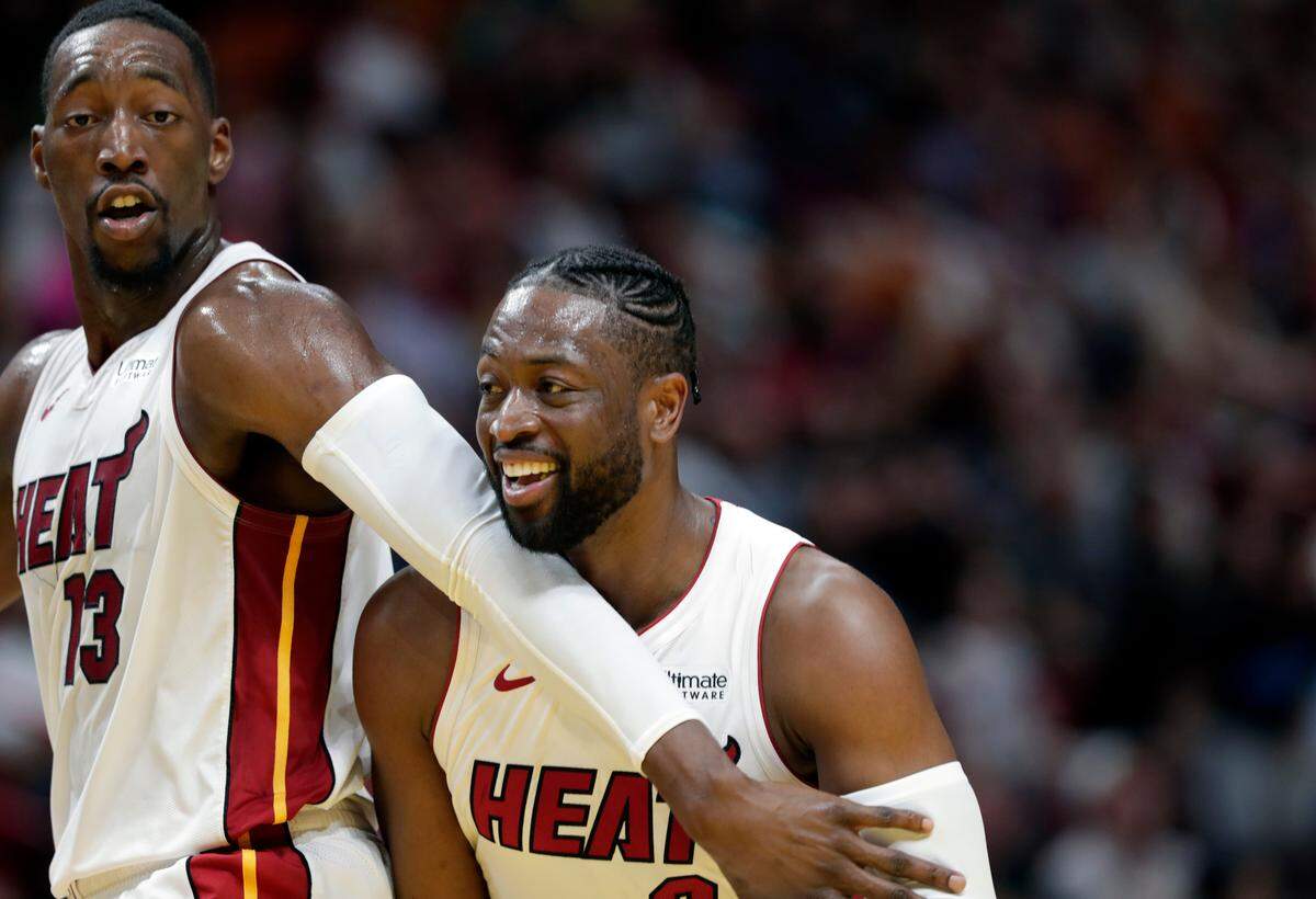 Miami Heat center Bam Adebayo (13) jokes with guard Dwyane Wade during the second half of an April 3 game against the Celtics.