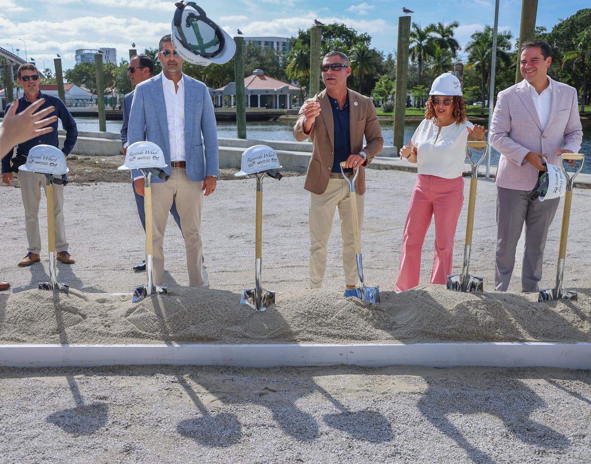 Mayor Francis Suarez, center, tosses a hard during the groundbreaking for the Riverside Wharf.