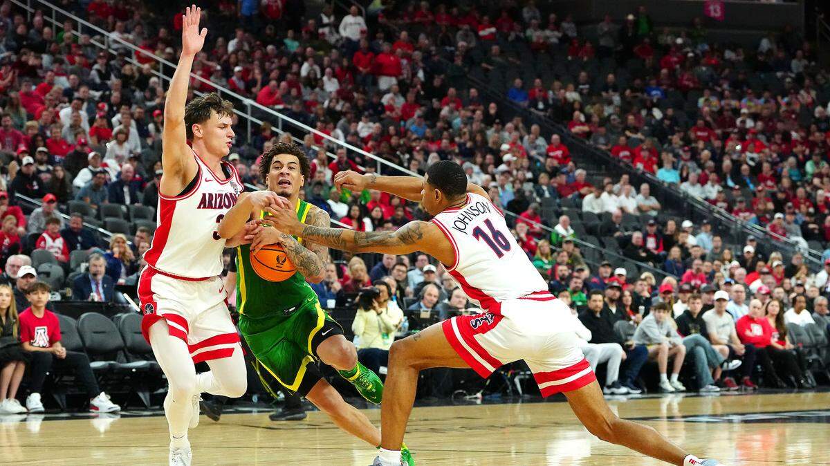 Oregon Ducks guard Jadrian Tracey (22) dribbles between Arizona Wildcats guard Pelle Larsson (3) and Arizona Wildcats forward Keshad Johnson (16) during the first half at T-Mobile Arena.