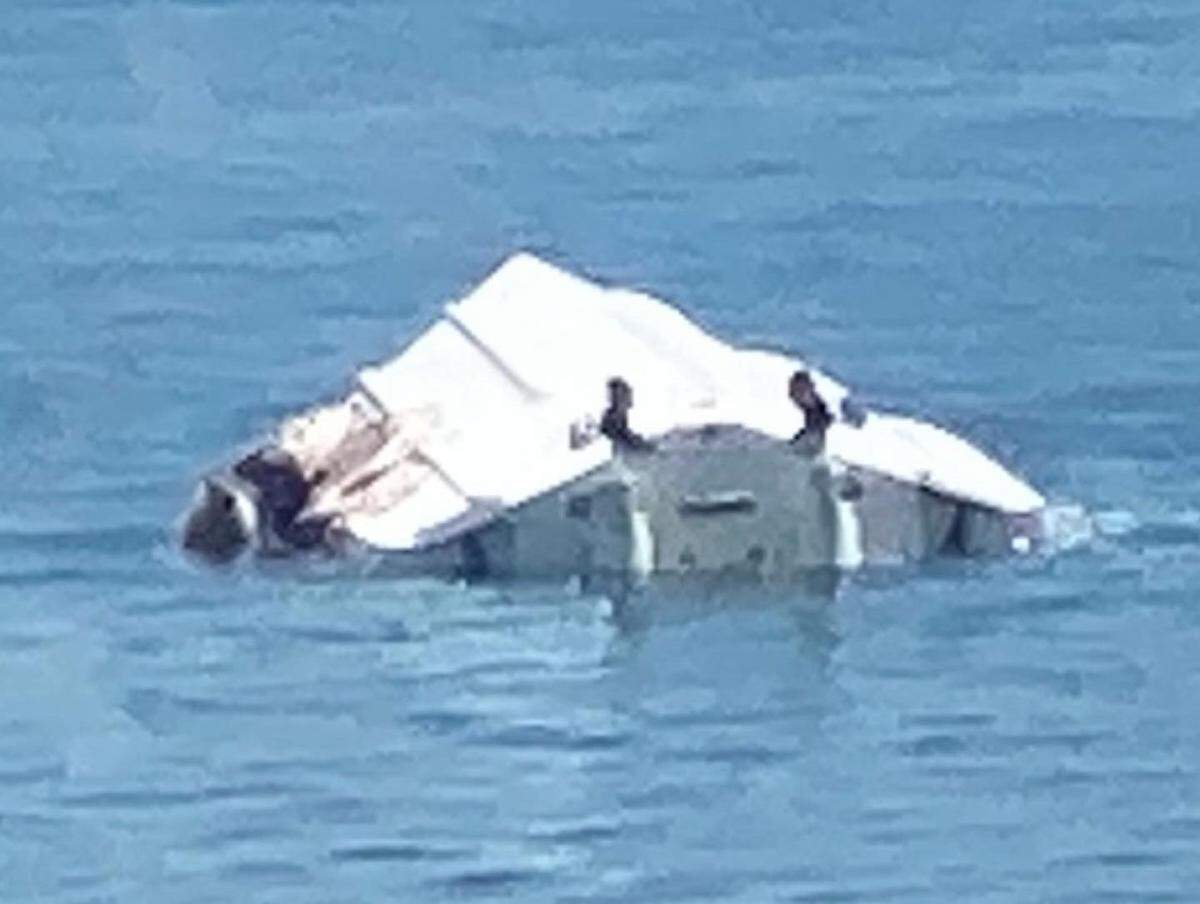 The 29-foot Robalo, piloted by George Pino, that struck a channel marker near North Key Largo on Labor Day weekend 2022 capsized, throwing all aboard into the water. This photo taken on the scene, shows the upside down vessel also had heavy damage along its starboard, or right, side. One person died in the crash, and another was severely injured.