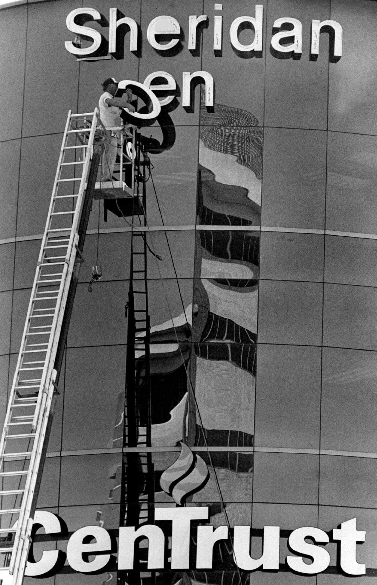 A worker installs a neon sign on the new Sheridan Financial Center on the corner of 41st Street and Sheridan Avenue in 1987.