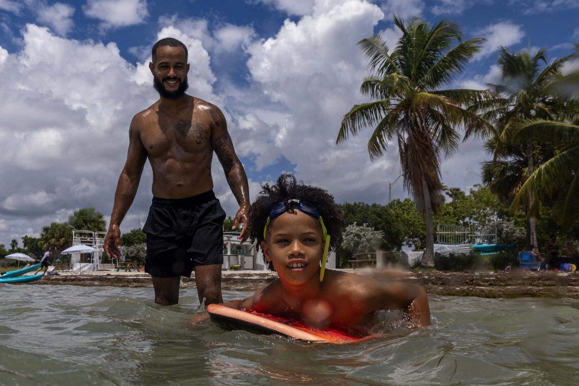 Ezekiel, 10, paddles on his boogie board as his father Carlos Antepara, 35, watches closely while at Hobie Island Beach on Monday, September 1, 2025, in Key Biscayne, Fla.
