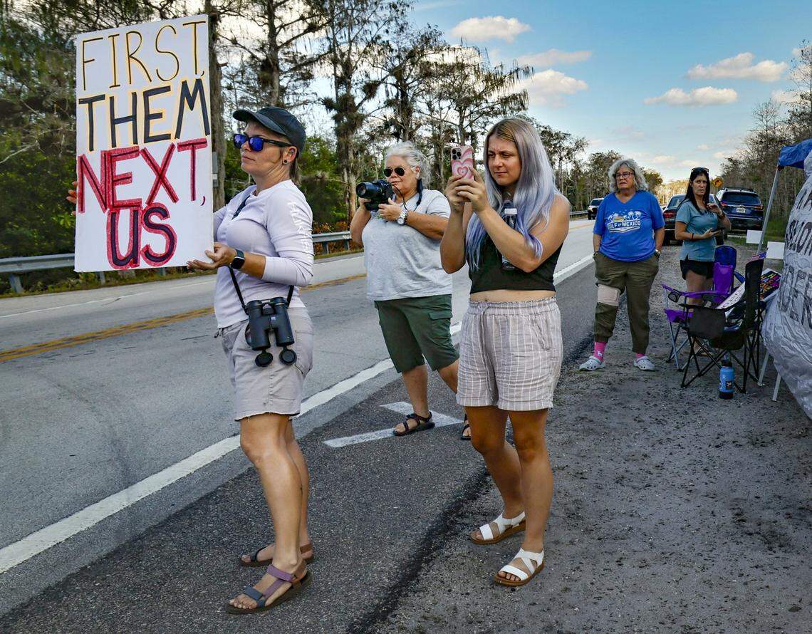 A group of protestors flash protest signs and take photographs of vehicles entering and leaving Alligator Alcatraz along Tamiami Trail on Wednesday, November 19, 2025. They have been camping during the day outside of the immigration detention facility since it's opening. Alligator Alcatraz is located at Dade-Collier Training and Transition Airport inside Big Cypress National Preserve in Ochopee, Florida.