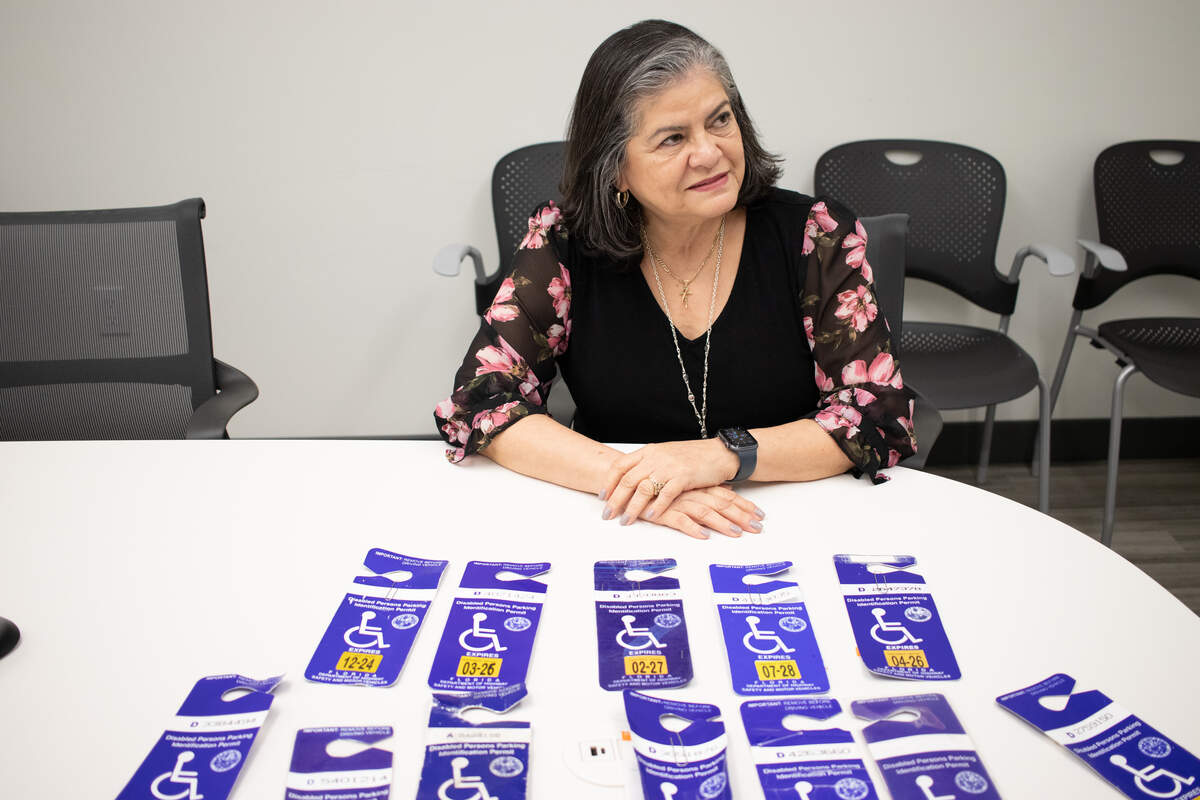 Monica Beltran, the director of parking, sustainability and mobility services for Coral Gables, shows some of the fraudulent disability permits code enforcement officers have confiscated.