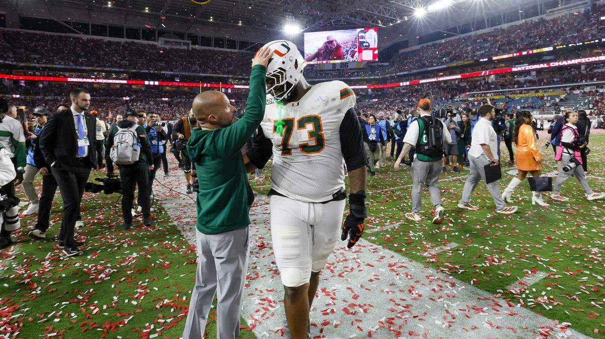 Miami Hurricanes offensive lineman Anez Cooper (73) is consoled on the field after the Canes are defeated by the Indiana Hoosiers in the College Football Playoff National Championship Game at Hard Rock Stadium in Miami Gardens, Florida, on Monday, January 19, 2026.